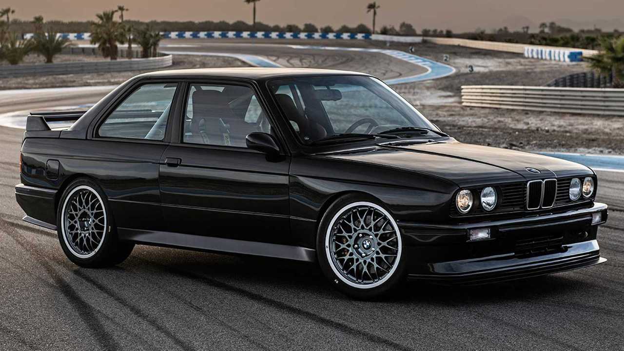 BMW noire classique sur piste de course.